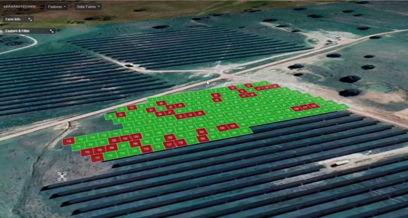 Aerial view of irrigation pipes with a central grid of green and red squares marking field plots or zones for crop planning.
